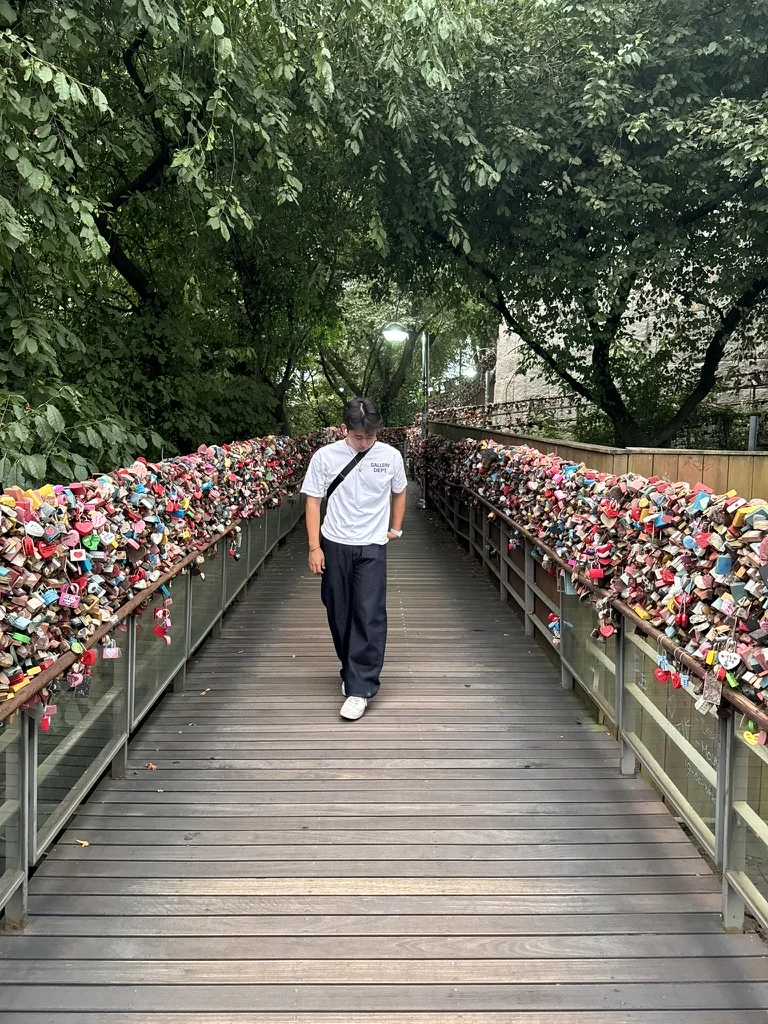 Aiden on a bridge lined with colorful locks