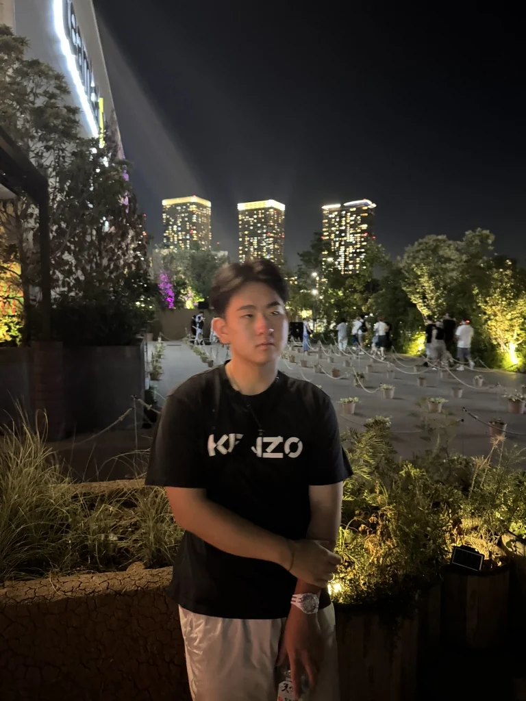 Aiden outdoors beneath the trees at night