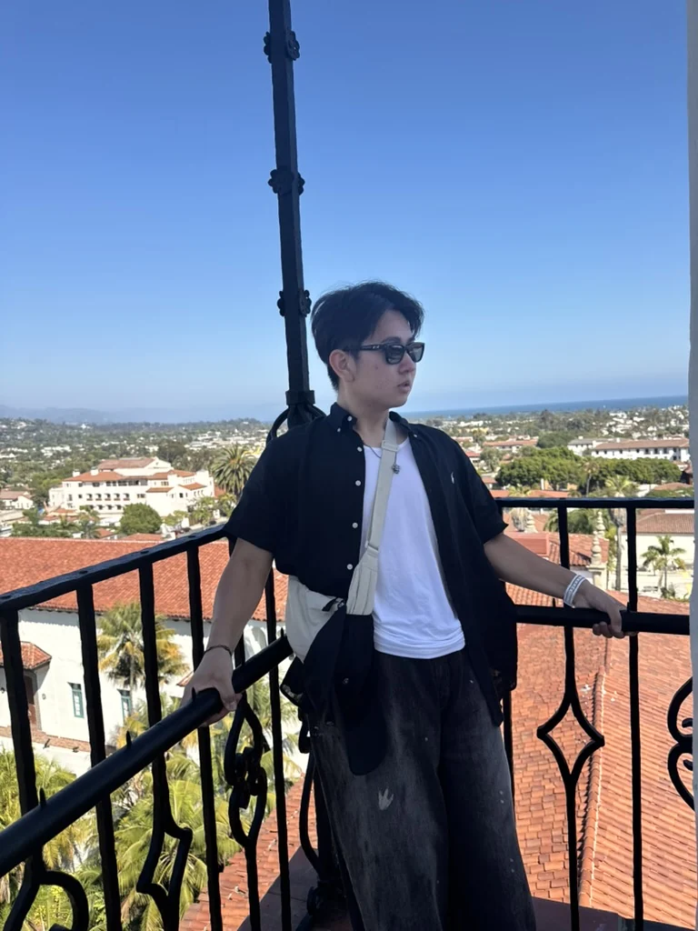 Aiden overlooking the city from a balcony